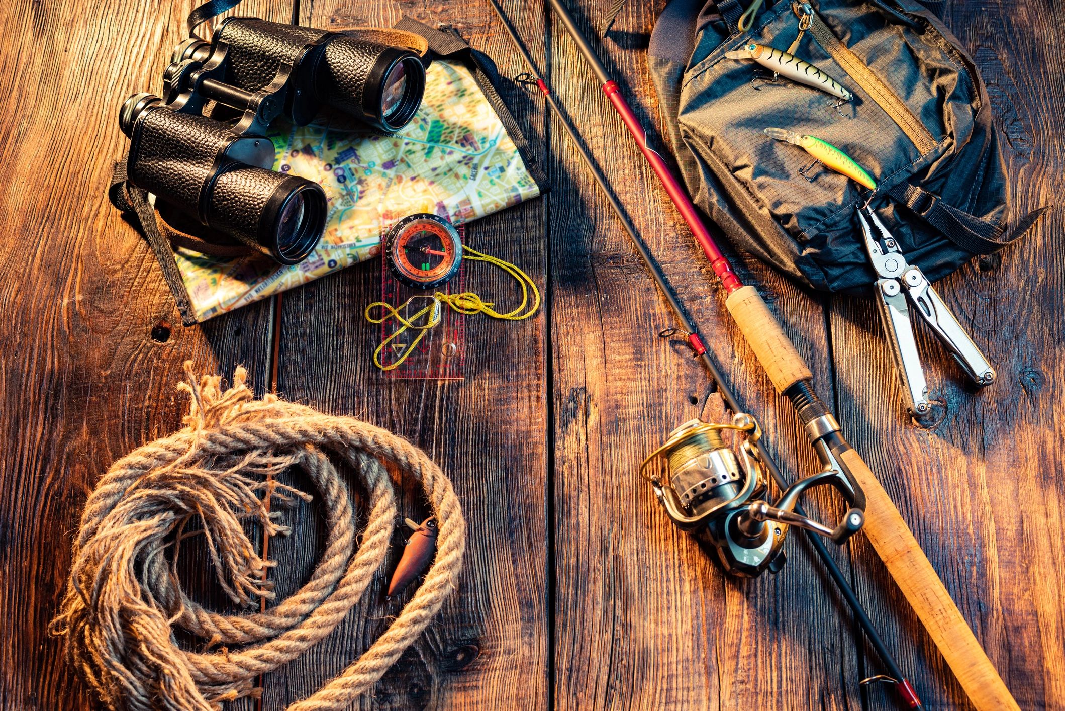 A table with fishing gear and binoculars on it.