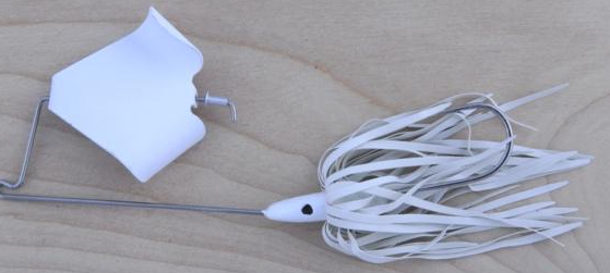 White fishing lure with rubber skirt.